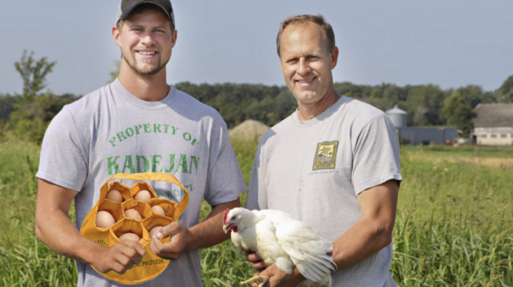 two farmers from HBF holding a carton of eggs and a chicken.